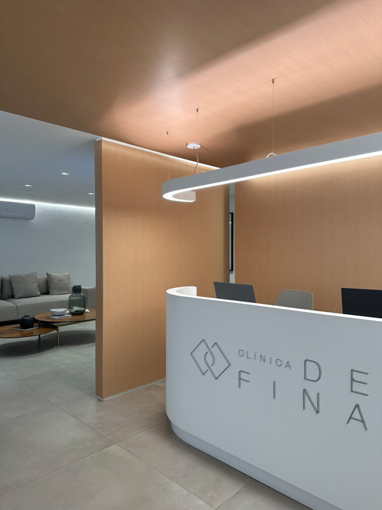 Balcão de recepção da Clínica De Fina com design moderno e ambiente sofisticado.