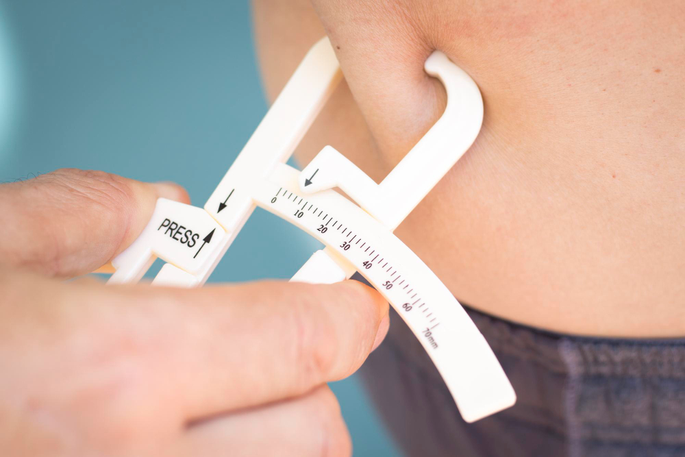 Medidor de dobras cutâneas avaliando gordura corporal.